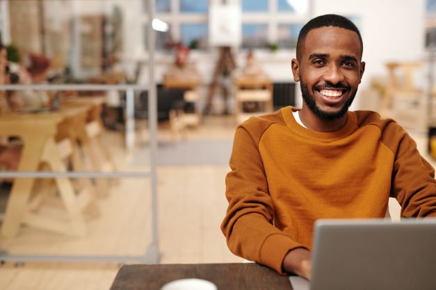 Smiling man using laptop - image by Diva Plavalaguna Smiling man using laptop - image by Diva Plavalaguna